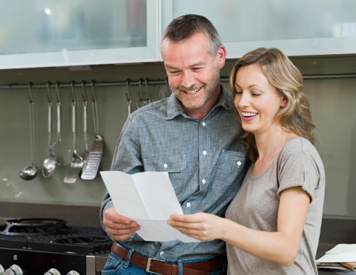 couple reading letter in kitchen from direct mail marketing service