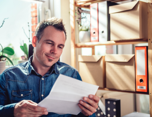 man in office reading letter he received